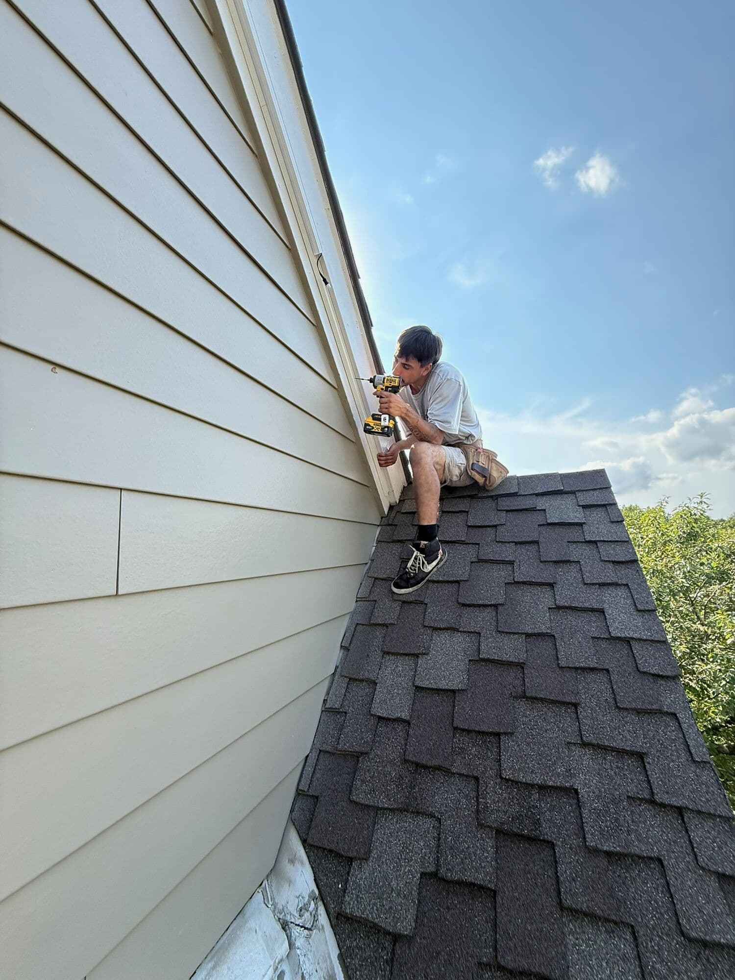 An installer working on an Omaha roofline in daylight